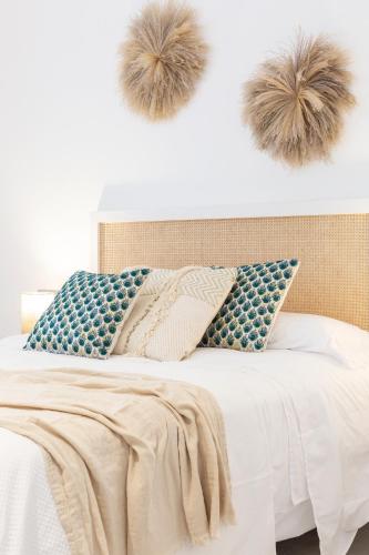 a bedroom with a bed with two faux fur pompoms on the wall at Apartamentos Martalia Nerja in Torrox
