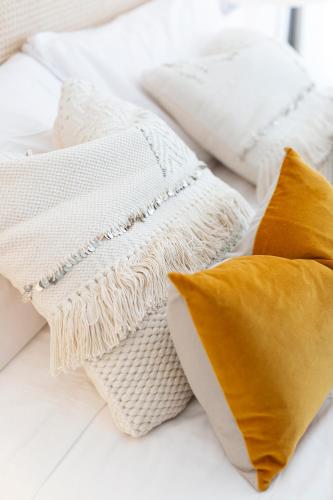 a pile of white blankets and pillows on a bed at Apartamentos Martalia Nerja in Torrox