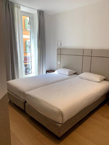 un grand lit dans une chambre avec une fenêtre dans l'établissement Share Inn Appartements, à Nice