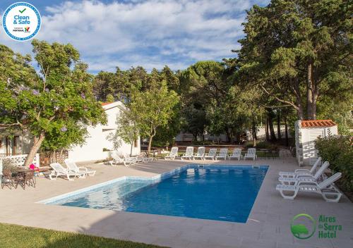 新托里什的住宿－Aires da Serra Hotel，一个带躺椅的游泳池和一个游泳池