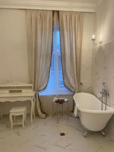 a white bathroom with a tub and a piano at Villa al Tempio in Pazardzhik