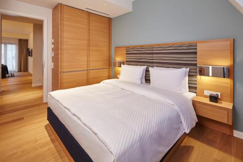 a bedroom with a large white bed with wooden walls at The Wellem, in The Unbound Collection by Hyatt in Düsseldorf