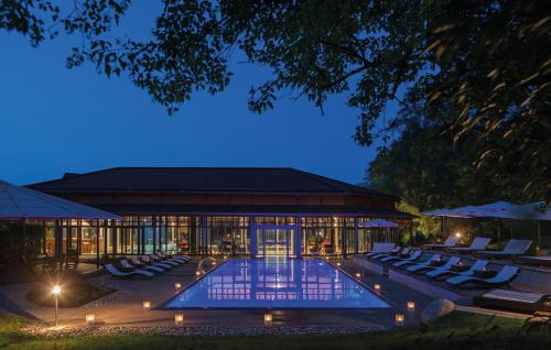 a building with a swimming pool at night at Parkhotel Adler in Hinterzarten