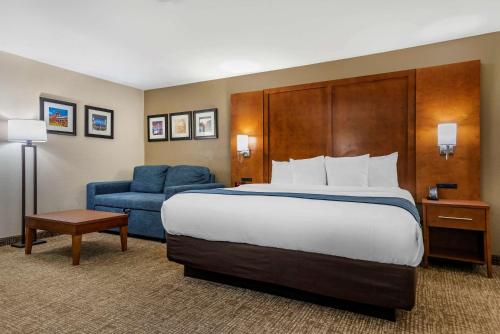 une chambre d'hôtel avec un lit et une chaise bleue dans l'établissement Comfort Inn Birmingham - Irondale, à Birmingham