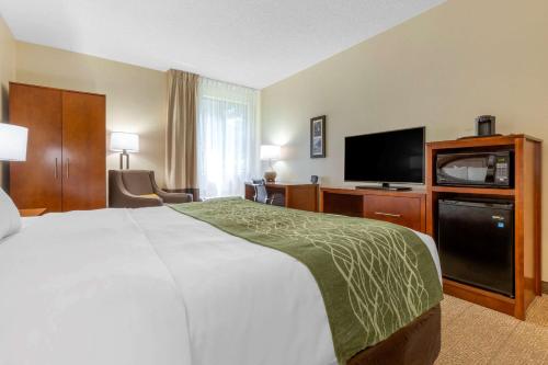 a hotel room with a bed and a flat screen tv at Comfort Inn & Suites Lenoir Hwy 321 Northern Foothills in Lenoir