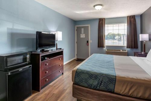 a bedroom with a bed and a flat screen tv at Econo Lodge Inn & Suites Sandusky South in Sandusky
