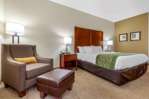 a hotel room with a bed and a chair at Comfort Inn & Suites Lenoir Hwy 321 Northern Foothills in Lenoir