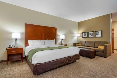 a hotel room with a large bed and a couch at Comfort Inn & Suites Lenoir Hwy 321 Northern Foothills in Lenoir