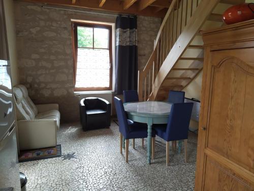 une salle à manger avec une table et des chaises bleues dans l'établissement Au Jardin près de l'ocean, aux Mathes