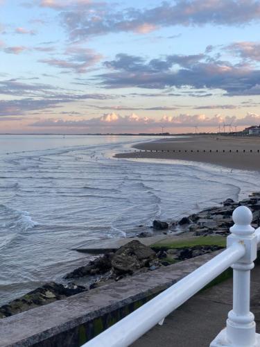 a view of the beach with a white fence at Greyfriars Guest House in Bridlington