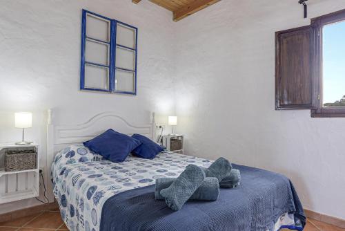 コニル・デ・ラ・フロンテーラにあるFinca Abril 3 Piscina Compartidaのベッドルーム1室(靴2足のベッド1台付)