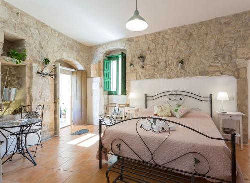um quarto com uma cama numa parede de pedra em Pura Vida Iblea em Ragusa