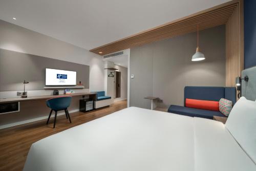 a hotel room with a bed and a tv at Holiday Inn Express Zhuhai Gongbei by IHG in Zhuhai