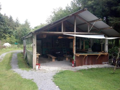 a wooden shed with a table and benches in it at Castaway Cabin in Tuamgraney