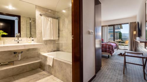 a bathroom with a tub and a sink and a bath tub at Pousada Geres-Caniçada in Caniçada