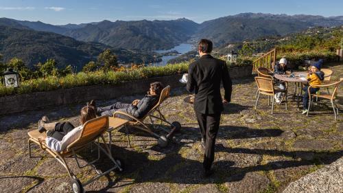 a man walking down a hill with people sitting in chairs at Pousada Geres-Caniçada in Geres