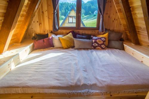 a large bed in a cabin with a window at Chamois Apartments Durmitor in Žabljak