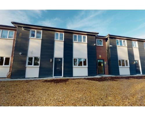 a large building with white doors on a street at Private Spacious 2 Bedroom, 2 Bathroom & 2 Parking by Srk Accommodation in Peterborough