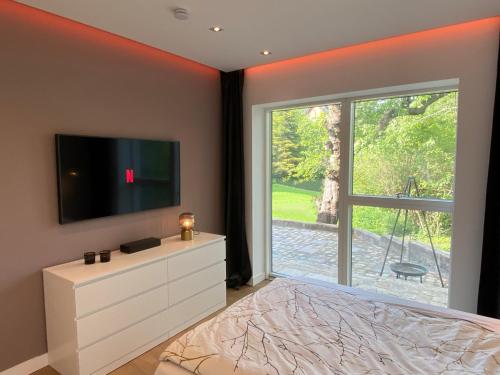 a bedroom with a flat screen tv on a wall at “STADT-LAND-SCHEUNE” - luxuriös in alten Gemäuern in Braunschweig