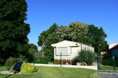 a small white house in a yard with trees at Ubytování Levandule in Košín