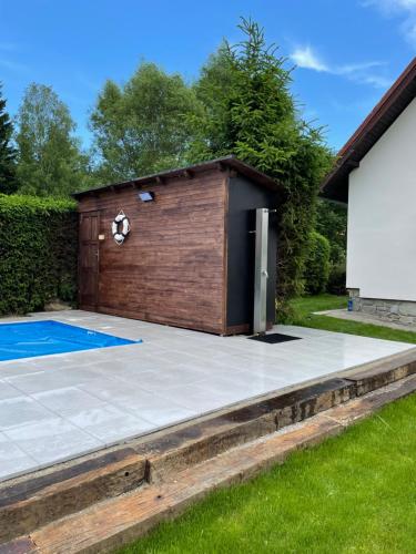 a backyard with a swimming pool and a building at Holiday house Lipno-Slupecna in Lipno nad Vltavou