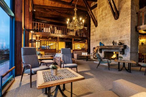 a living room with chairs and a fireplace at Pousada Geres-Caniçada in Geres