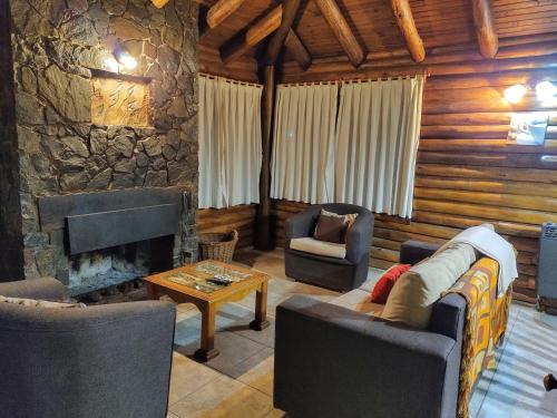 ein Wohnzimmer mit Sofas und einem Steinkamin in der Unterkunft Mendoza Sol y Nieve in Potrerillos
