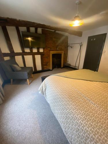 a bedroom with a bed and a tv and a chair at Charles I 16th century house in Newark-on-Trent