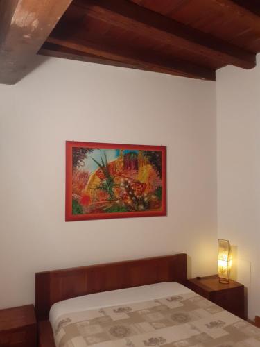 a bedroom with a bed and a painting on the wall at La Corte Dei Cappuccini in Bergamo