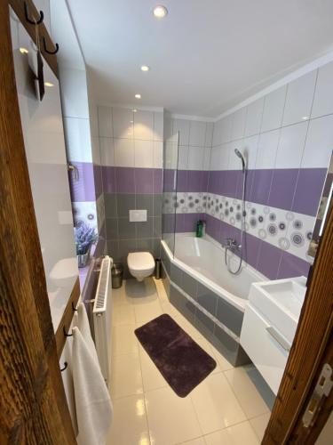 a purple and white bathroom with a tub and a sink at Matrix in Tatranská Lomnica