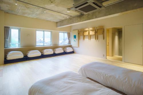 a room with four beds in a room with windows at TAKAONE ACTIVITY＆STAY in Hachioji
