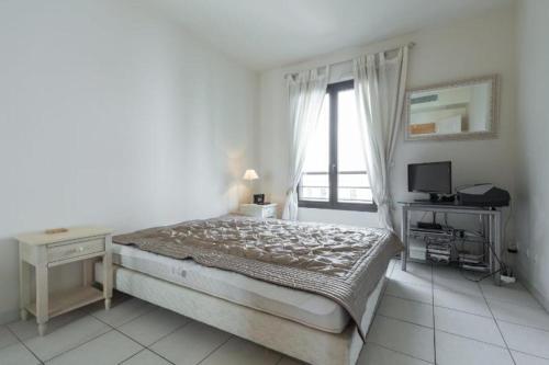 une chambre avec un lit, un bureau et une fenêtre dans l'établissement Cannes centre 2mins from beach stunning 3-Bed Apt, à Cannes