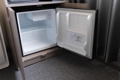 an empty refrigerator with its door open in a kitchen at Route Inn Grantia Tokai Spa&Relaxation in Tokai