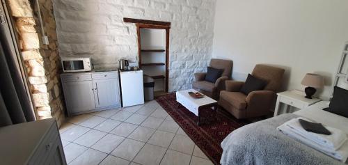 a small living room with a couch and a kitchen at Oudeklip Guesthouse Nieuwoudtville in Nieuwoudtville