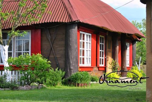 une petite maison avec un toit rouge et des fenêtres rouges dans l'établissement Садиба "ОРНАМЕНТ", à Szack