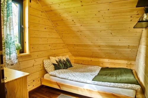 a wooden cabin with a bed in a room at Polana Świerkowa in Okuninka