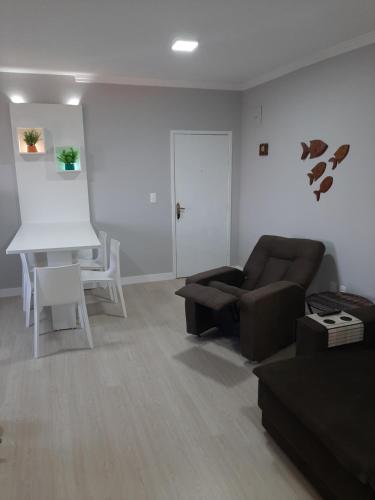 ein Wohnzimmer mit einem Sofa und einem Tisch in der Unterkunft Apartamento na Praia da Enseada, 100 mt praia in São Francisco do Sul