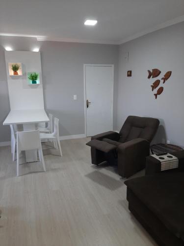 ein Wohnzimmer mit Sofa und Tisch in der Unterkunft Apartamento na Praia da Enseada, 100 mt praia in São Francisco do Sul