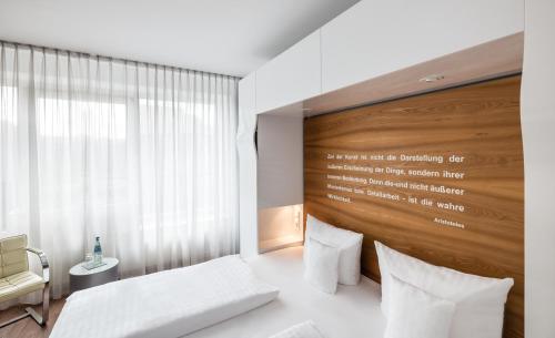 a bedroom with a white bed and a wooden wall at Art Hotel City Leipzig in Leipzig