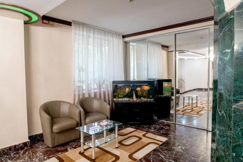 a living room with a fireplace and a tv at Hotel Palace Ukraine in Mykolaiv