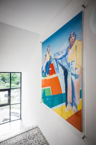 a mural on a wall in a room with a window at Art Hotel City Leipzig in Leipzig