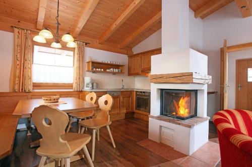 eine Küche mit einem Esstisch und einem Kamin in der Unterkunft Das Resort Brixen in Brixen im Thale
