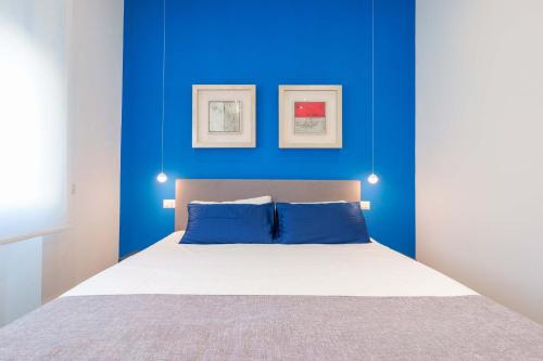 een blauwe slaapkamer met een bed met blauwe muren bij Suite nel Largo in Cagliari