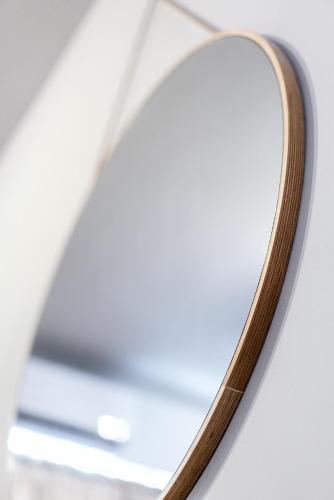 a mirror on a table with a wooden handle at Unique Experience Apartment’s in Thessaloniki