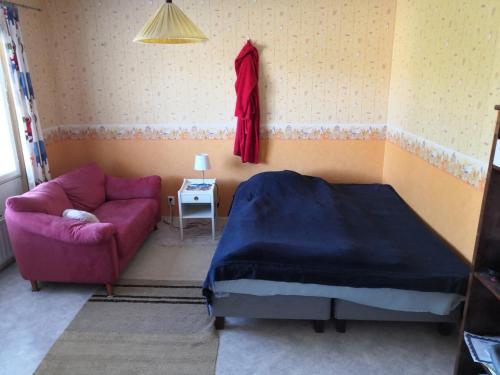 um quarto com uma cama roxa e um sofá em Homestay cozy hosting em Tervakoski