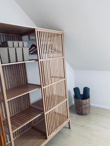 a wooden book shelf in a room with two blue chairs at Ferienwohnung im Romantikhof in Breitenbrunn