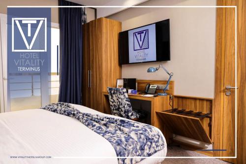 a hotel room with a bed and a desk at Hotel Vitality Terminus in Kenitra