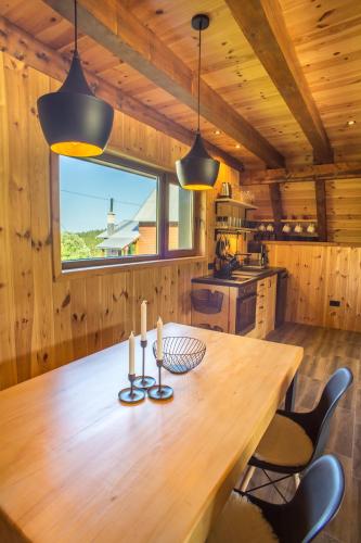 a wooden table in a kitchen with two candles at Chamois Apartments Durmitor in Žabljak