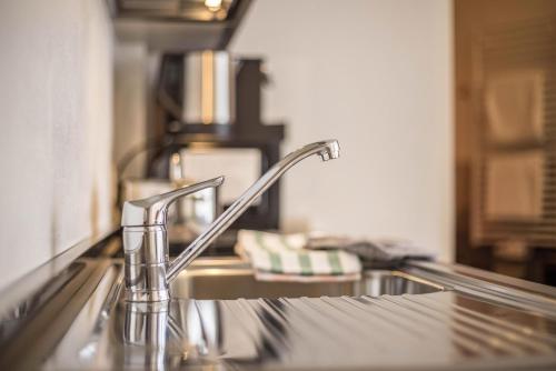 a kitchen sink with a faucet on a counter at Apartment Cinch Residence Bun Ste in San Vigilio Di Marebbe