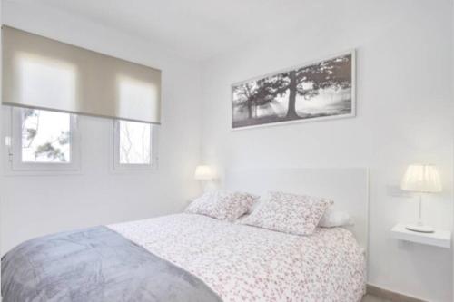 biała sypialnia z łóżkiem i 2 oknami w obiekcie Aldara Home by Best Holidays Fuerteventura w Corralejo